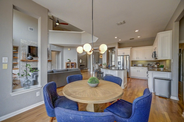 dining room featuring visible vents, ceiling fan with notable chandelier, recessed lighting, light wood finished floors, and baseboards