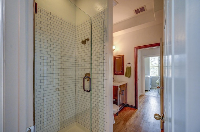 full bath with vanity, wood finished floors, visible vents, and a stall shower