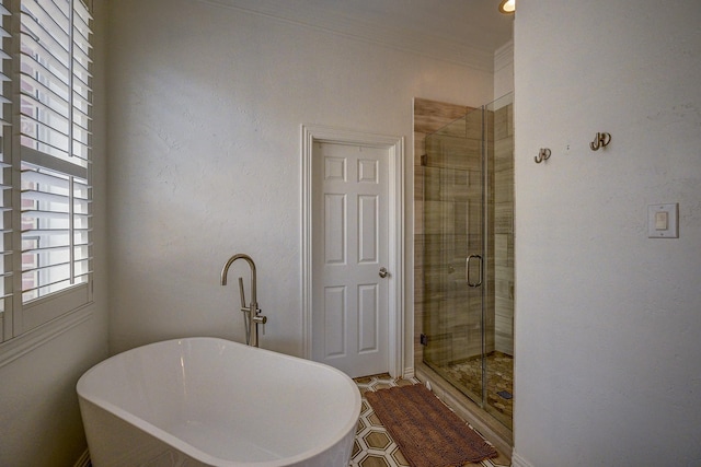 bathroom featuring crown molding, a freestanding tub, and a stall shower