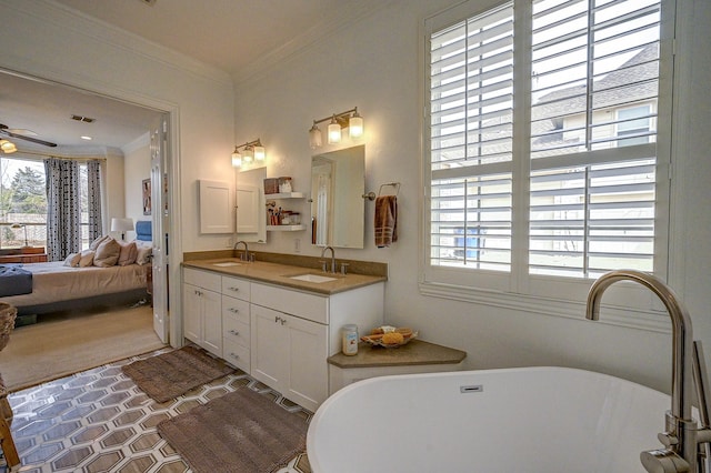 ensuite bathroom featuring crown molding, a freestanding tub, connected bathroom, and a sink