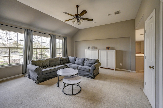 living area featuring baseboards, visible vents, ceiling fan, vaulted ceiling, and light carpet