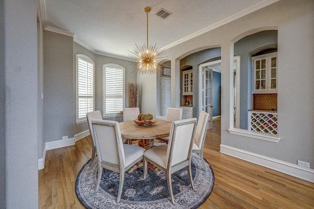 dining area with visible vents, baseboards, ornamental molding, french doors, and wood finished floors