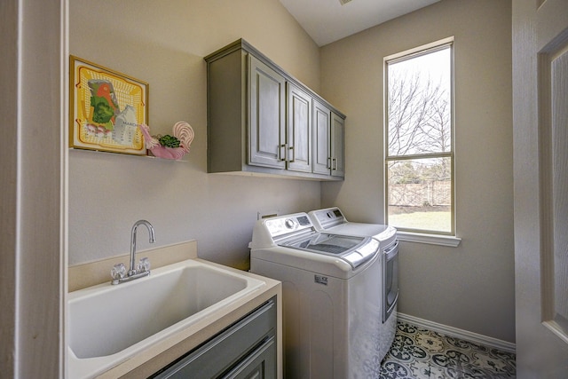 washroom featuring baseboards, light tile patterned floors, washer and dryer, cabinet space, and a sink