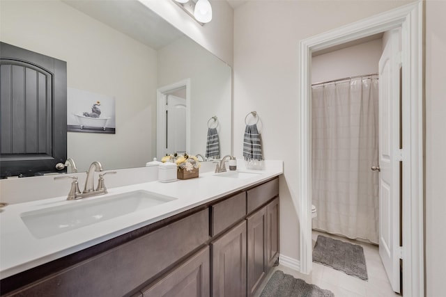 full bathroom featuring a sink, toilet, double vanity, and tile patterned flooring