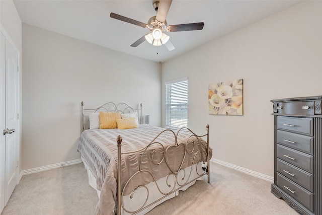 bedroom with baseboards, light carpet, and a ceiling fan