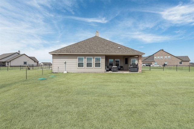 rear view of property featuring a yard, a patio, a fenced backyard, and a chimney