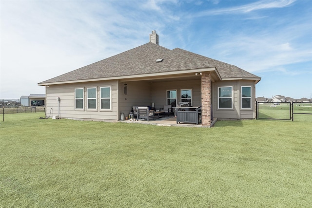 rear view of house with a patio, roof with shingles, a yard, and fence