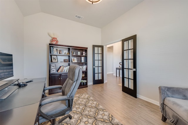 office area featuring wood finished floors, baseboards, visible vents, vaulted ceiling, and french doors