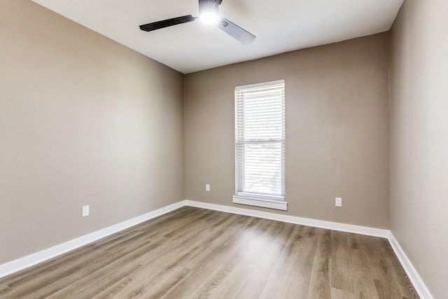 unfurnished room featuring baseboards, wood finished floors, and a ceiling fan