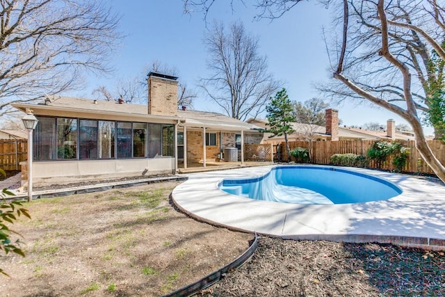 view of swimming pool with cooling unit, a fenced backyard, a fenced in pool, and a sunroom