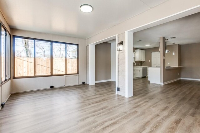 unfurnished living room featuring baseboards and wood finished floors