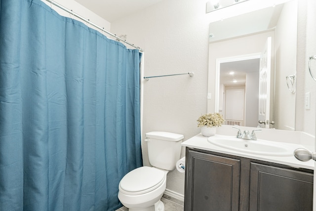 bathroom with baseboards, toilet, and vanity