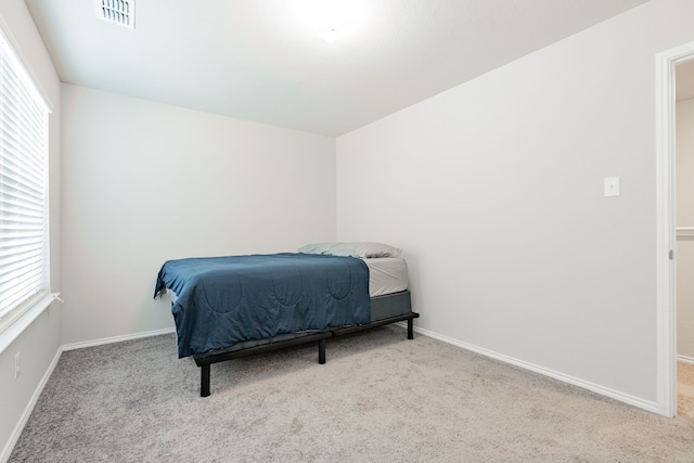 carpeted bedroom featuring visible vents and baseboards