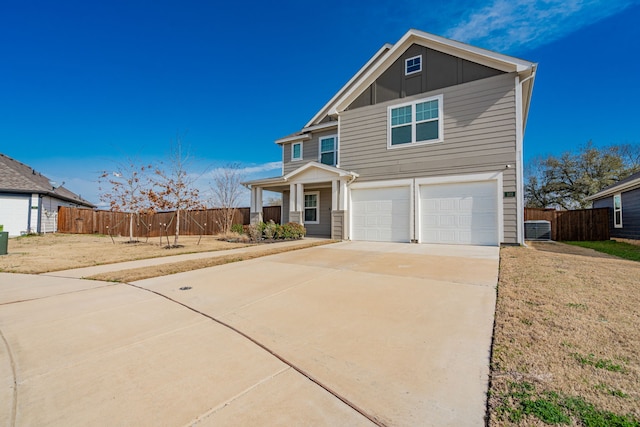 view of front of home featuring an attached garage, board and batten siding, driveway, and fence