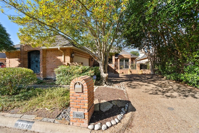 view of front facade with brick siding and a garage