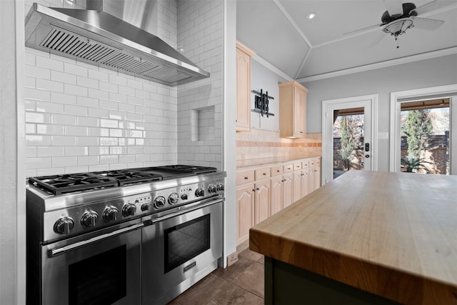 kitchen featuring ornamental molding, light brown cabinetry, double oven range, wall chimney range hood, and vaulted ceiling