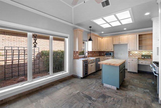 kitchen with visible vents, a sink, a kitchen island, stainless steel appliances, and wooden counters