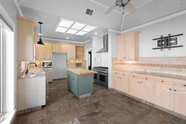 kitchen featuring visible vents, a sink, butcher block countertops, stainless steel appliances, and wall chimney range hood