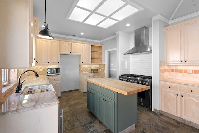 kitchen with butcher block countertops, light brown cabinetry, a sink, stainless steel appliances, and wall chimney range hood