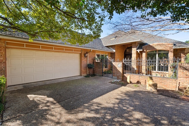 ranch-style house featuring brick siding, an attached garage, driveway, and a shingled roof