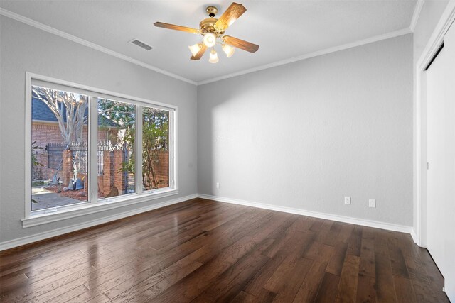 spare room with visible vents, baseboards, dark wood-style floors, and ornamental molding