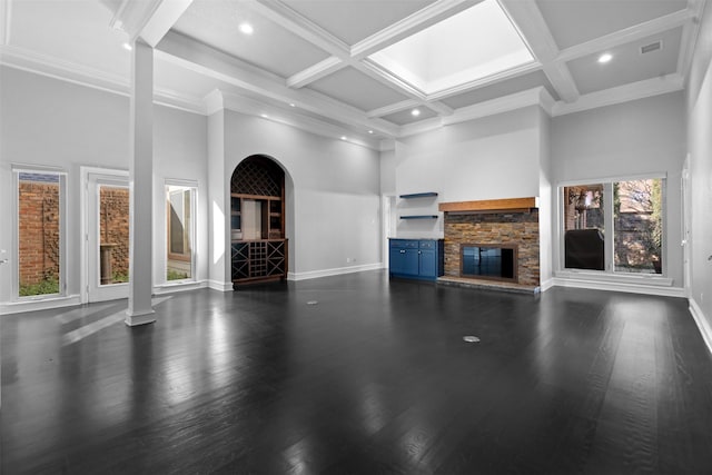 unfurnished living room featuring visible vents, dark wood-type flooring, and a towering ceiling