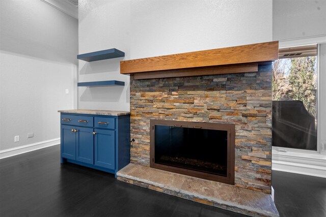 room details with baseboards, wood finished floors, and a fireplace