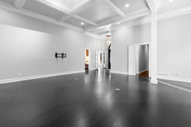 empty room featuring baseboards, coffered ceiling, visible vents, dark wood finished floors, and a towering ceiling