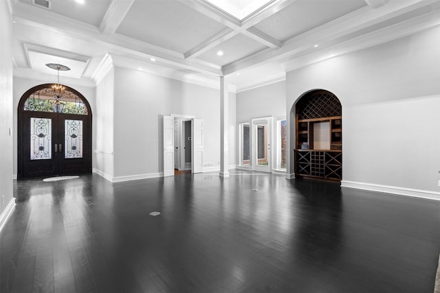 entryway with coffered ceiling, beam ceiling, dark wood-type flooring, french doors, and a notable chandelier