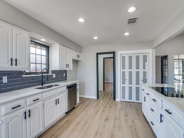 kitchen featuring visible vents, a sink, stainless steel dishwasher, decorative backsplash, and black electric stovetop