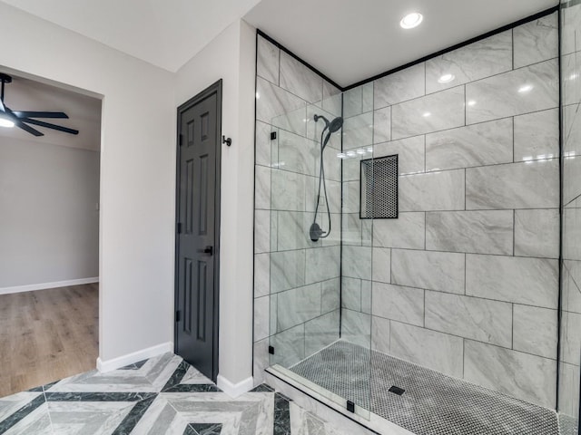 full bathroom featuring a shower stall, baseboards, and ceiling fan