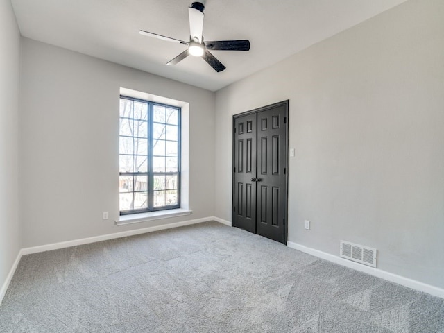 empty room with visible vents, ceiling fan, baseboards, and carpet floors