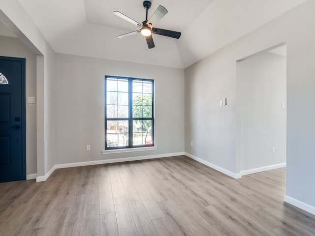 spare room featuring ceiling fan, lofted ceiling, baseboards, and wood finished floors