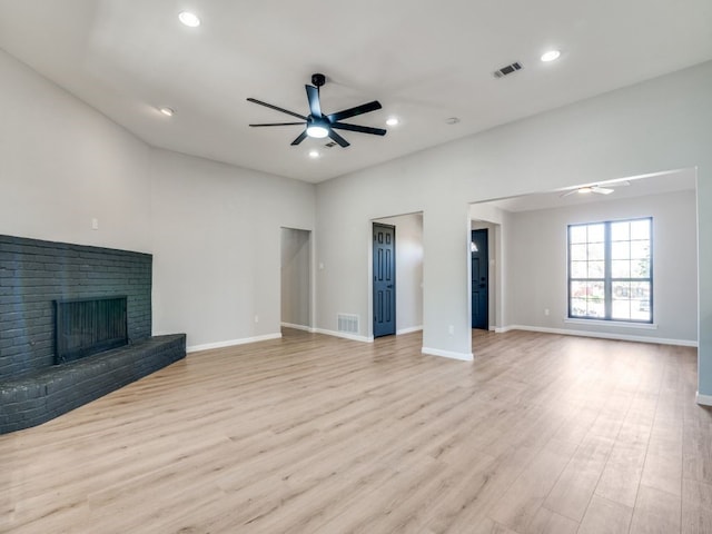 unfurnished living room with light wood-style flooring, ceiling fan, and a fireplace