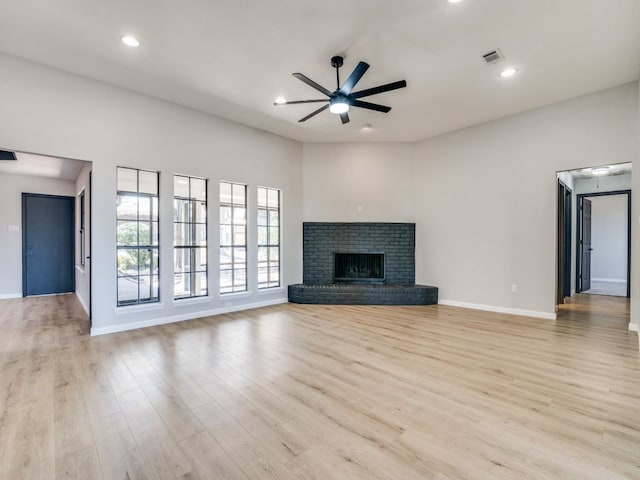 unfurnished living room with visible vents, light wood-style flooring, a ceiling fan, recessed lighting, and a brick fireplace