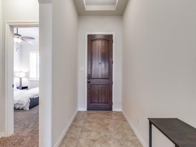 entrance foyer with ceiling fan and baseboards