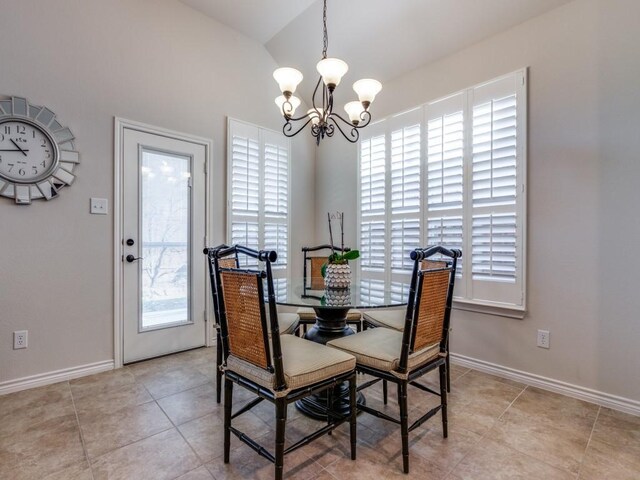 dining area featuring light tile patterned floors, baseboards, a chandelier, and vaulted ceiling