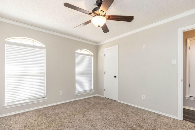 spare room with a ceiling fan, baseboards, a textured ceiling, and crown molding