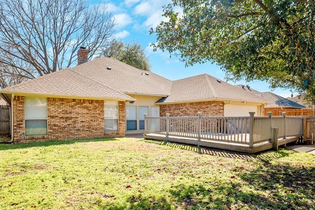 back of house featuring brick siding, a chimney, a lawn, and fence