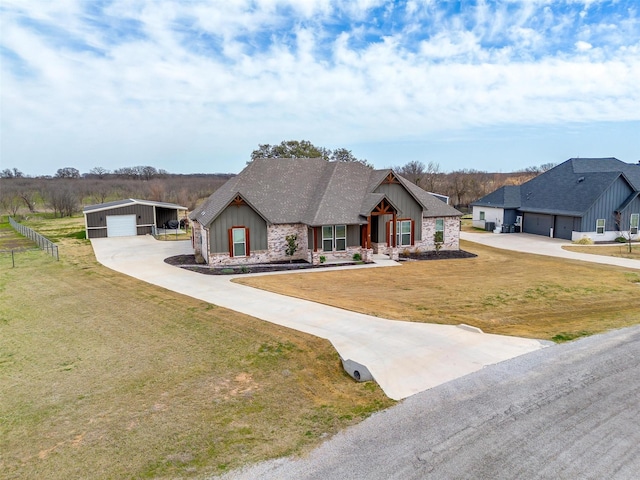 view of front of property featuring a detached garage, board and batten siding, and stone siding