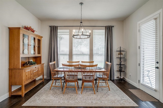 dining area featuring dark wood-style floors, baseboards, and a chandelier