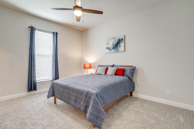 carpeted bedroom featuring multiple windows, a ceiling fan, and baseboards