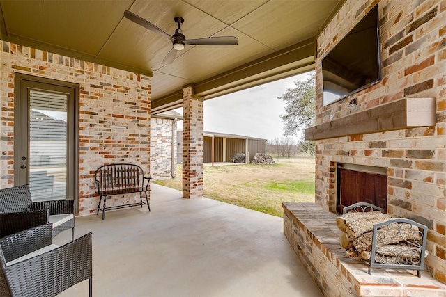 view of patio with a ceiling fan and an outdoor brick fireplace