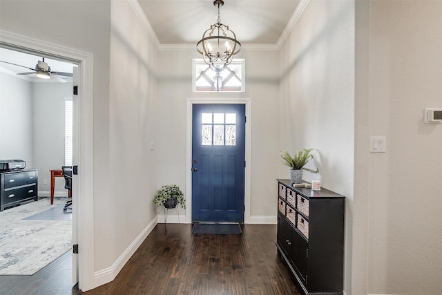 foyer with an inviting chandelier, dark wood-type flooring, baseboards, and ornamental molding