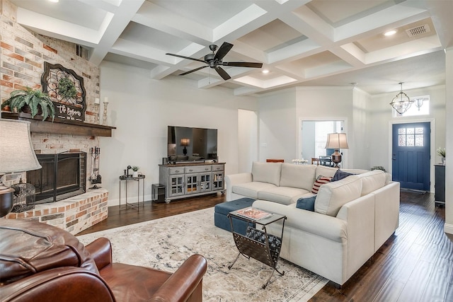 living area featuring baseboards, coffered ceiling, beam ceiling, a fireplace, and dark wood-type flooring