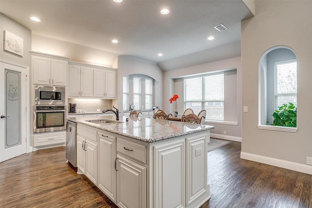 kitchen featuring dark wood finished floors, white cabinets, stainless steel appliances, and a sink