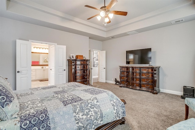 bedroom with a tray ceiling, baseboards, visible vents, and carpet floors