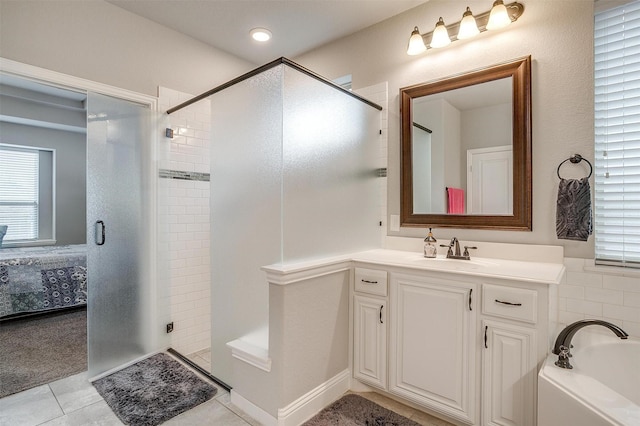 ensuite bathroom with tile patterned flooring, plenty of natural light, a stall shower, and vanity