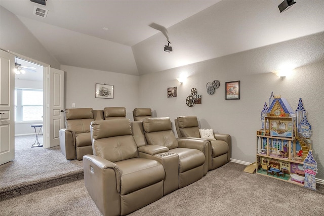 carpeted cinema room with visible vents, baseboards, and vaulted ceiling