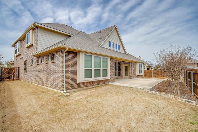 rear view of property featuring a patio area, brick siding, a fenced backyard, and a lawn